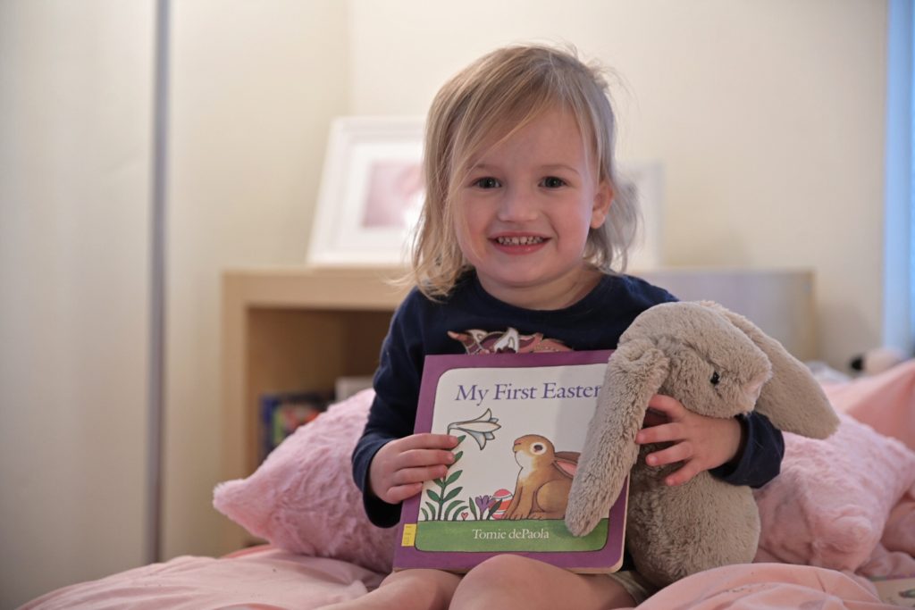 Ava reading My First Easter by Tomi dePaola